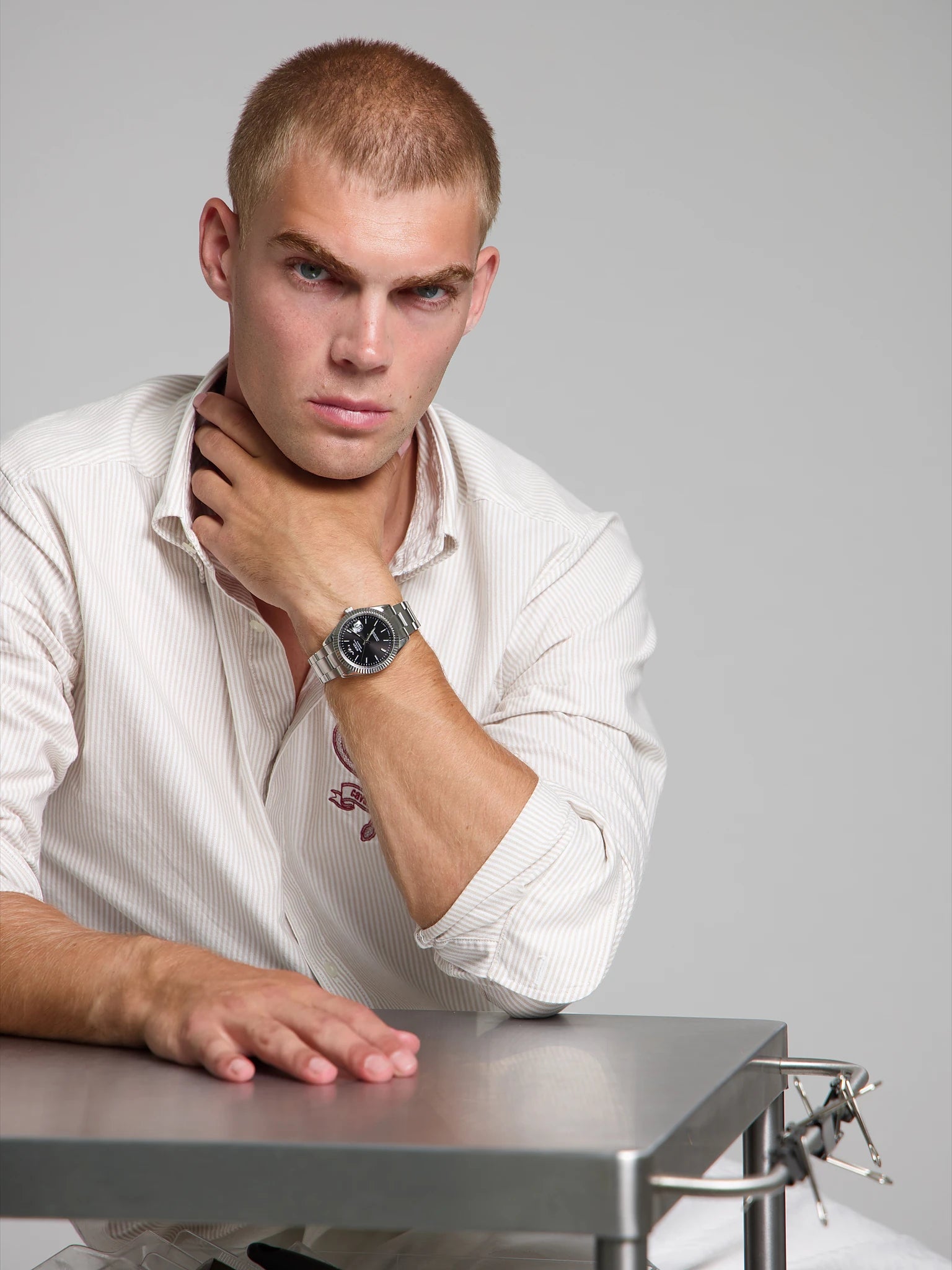 Model wearing a SOREN Momentis black watch on a oyster bracelet, seated
