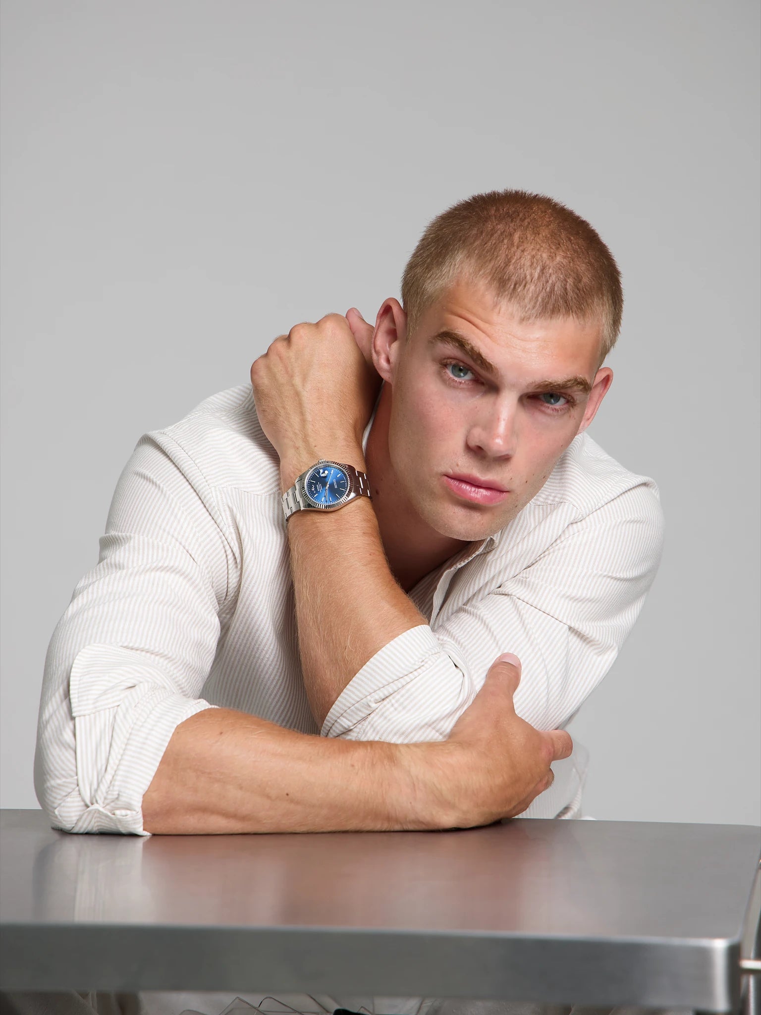 Model wearing a SOREN Momentis blue watch on a oyster bracelet, seated