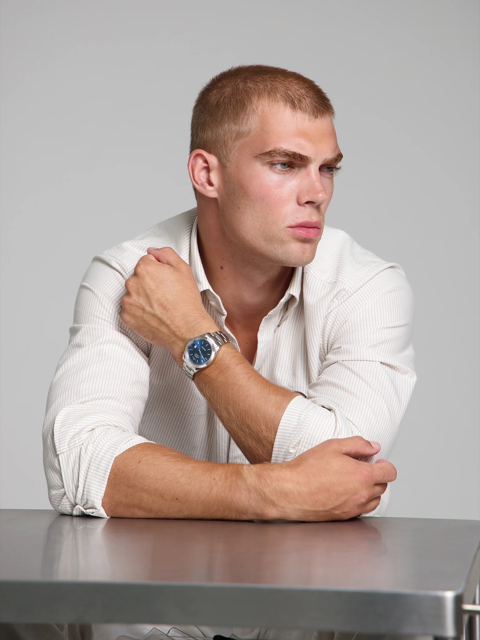 Model wearing a SOREN Momentis blue watch on a oyster bracelet, seated