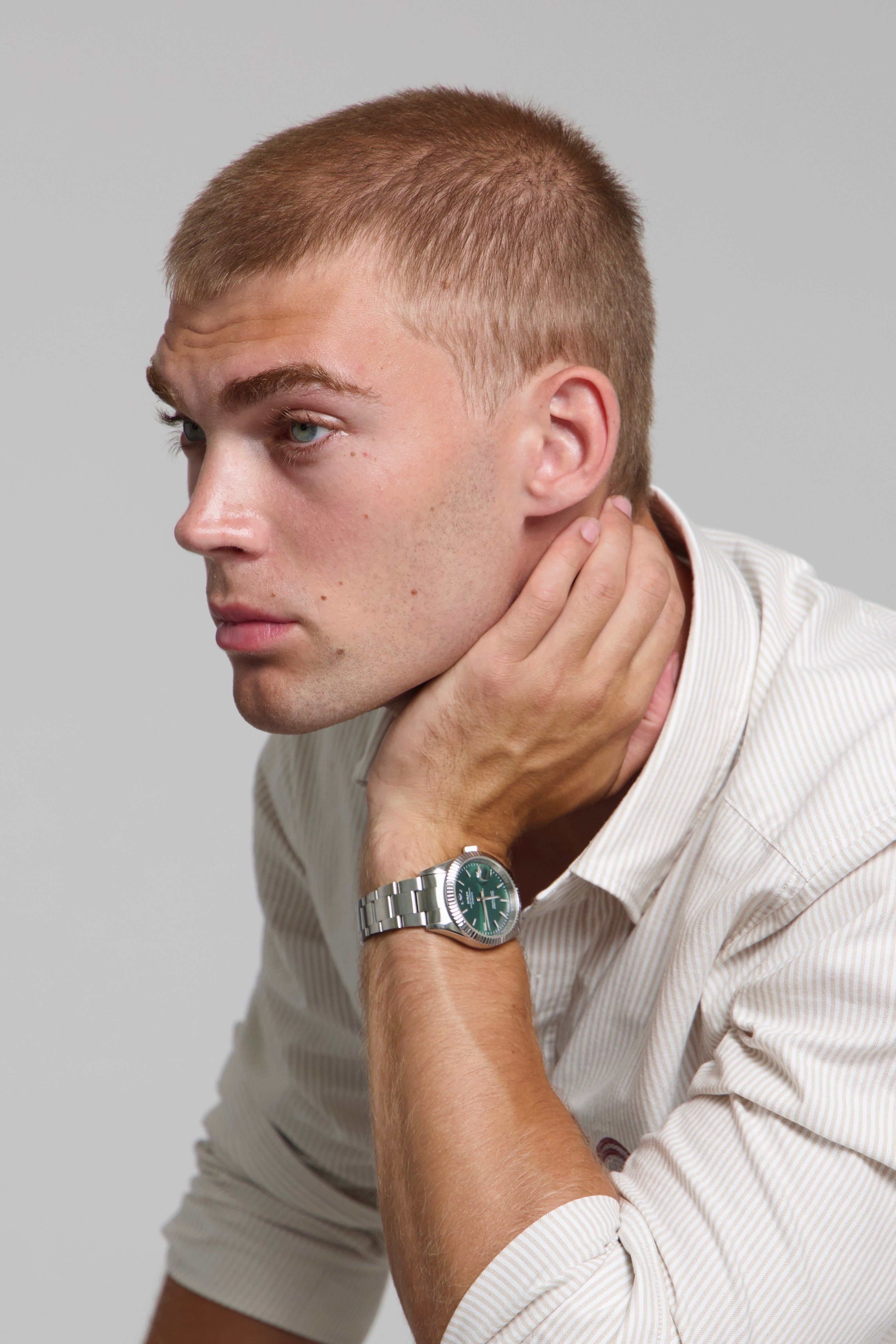 Model wearing a SOREN Momentis green watch on a oyster bracelet, seated