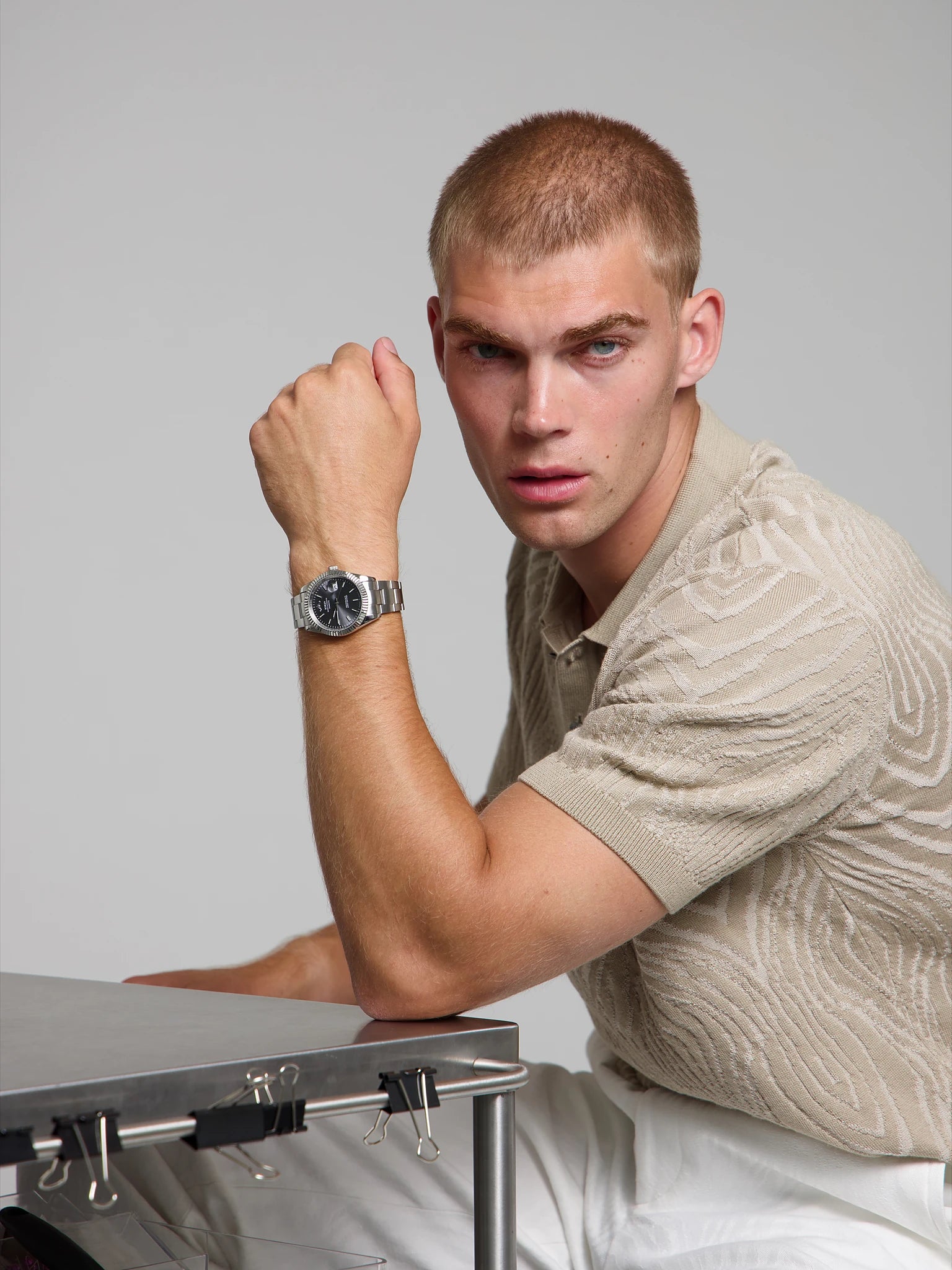 Man wearing a SOREN Momentis grey watch on a oyster bracelet, seated with his arm on a table