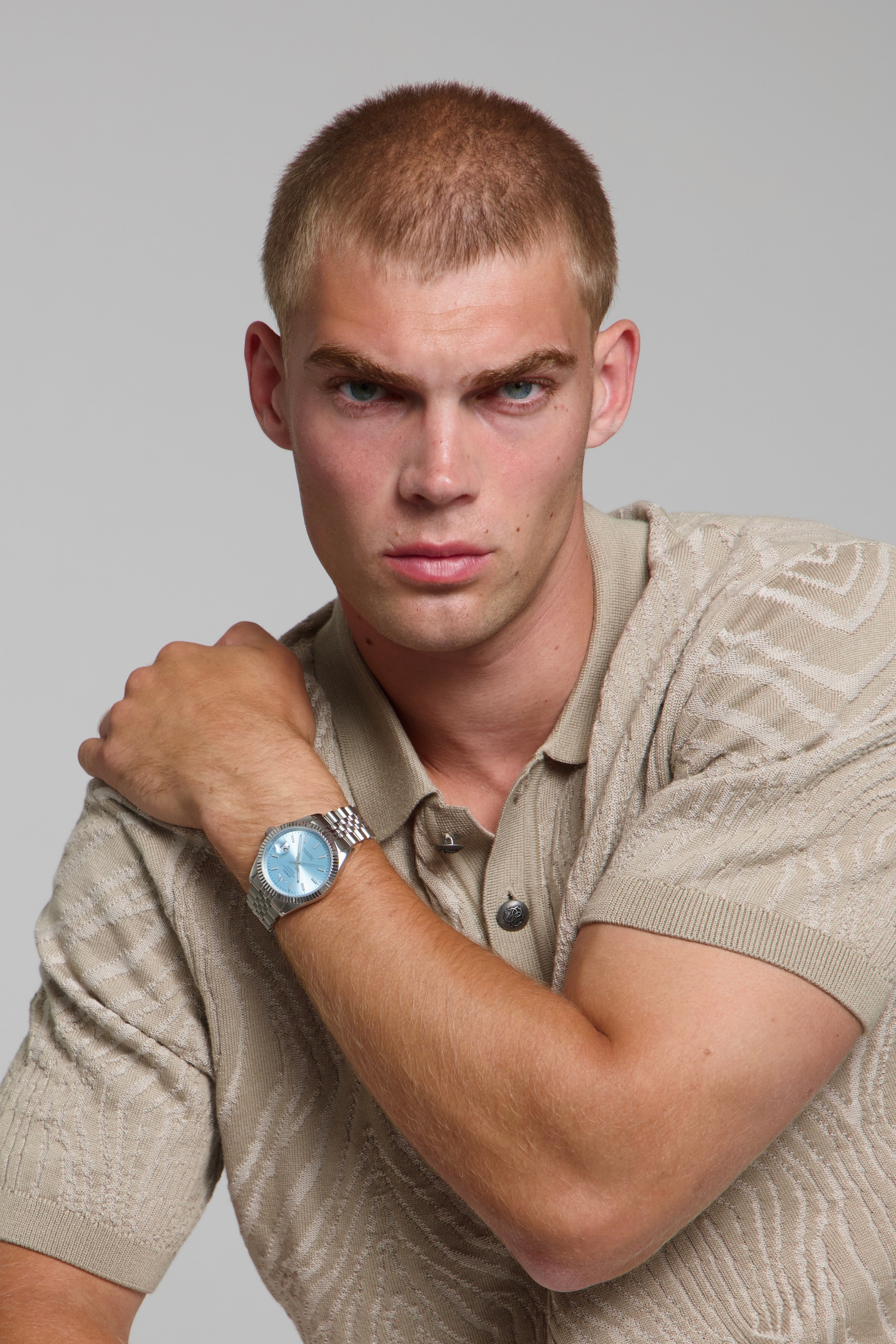 Model wearing a SOREN Momentis ice blue watch on a jubilee bracelet, seated