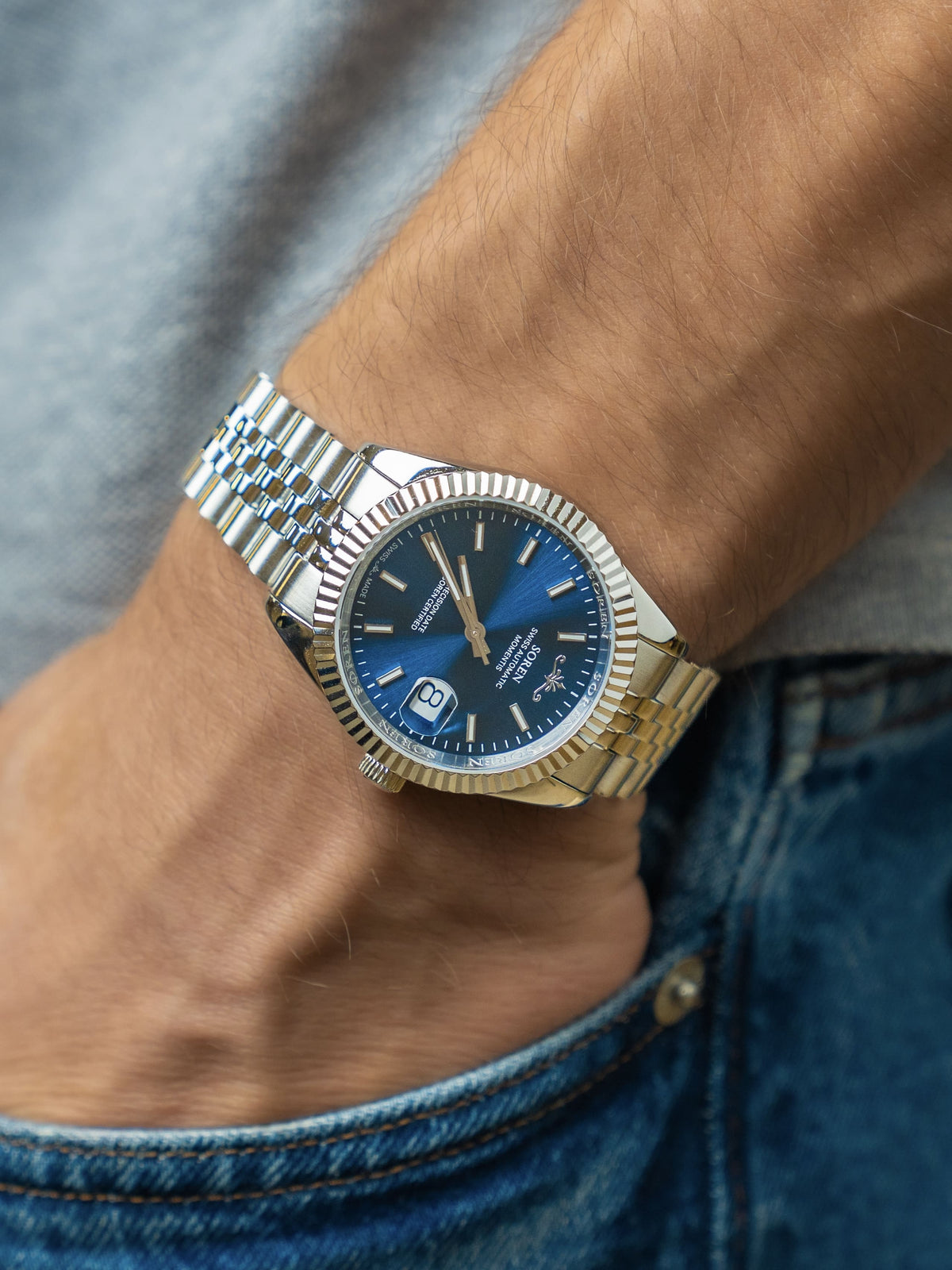 SOREN Momentis Swiss automatic watch with blue dial on a 5-link steel bracelet, worn on the wrist with hand in pocket