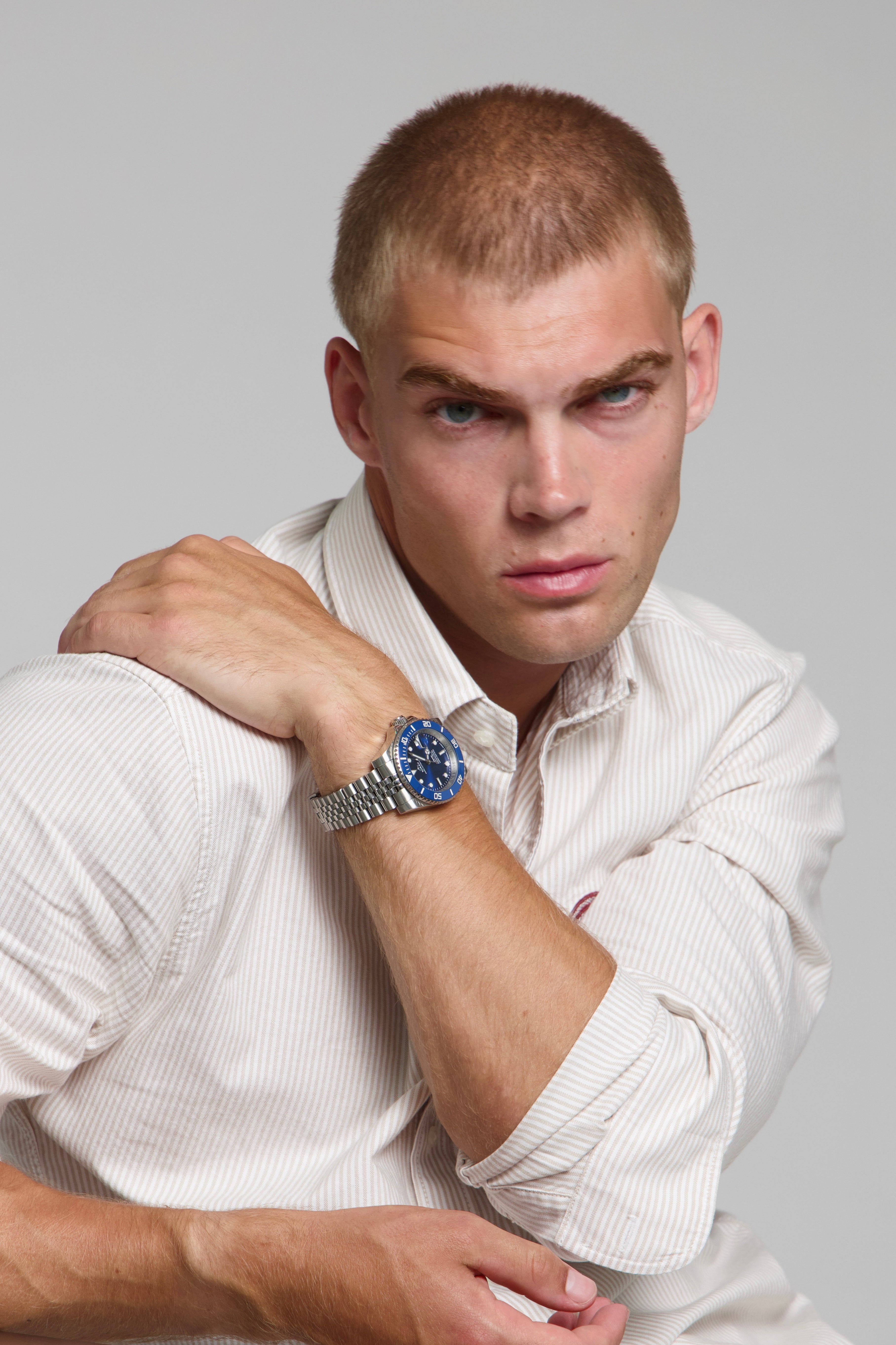 Model wearing a SOREN oceanic all blue watch on a jubilee bracelet, seated