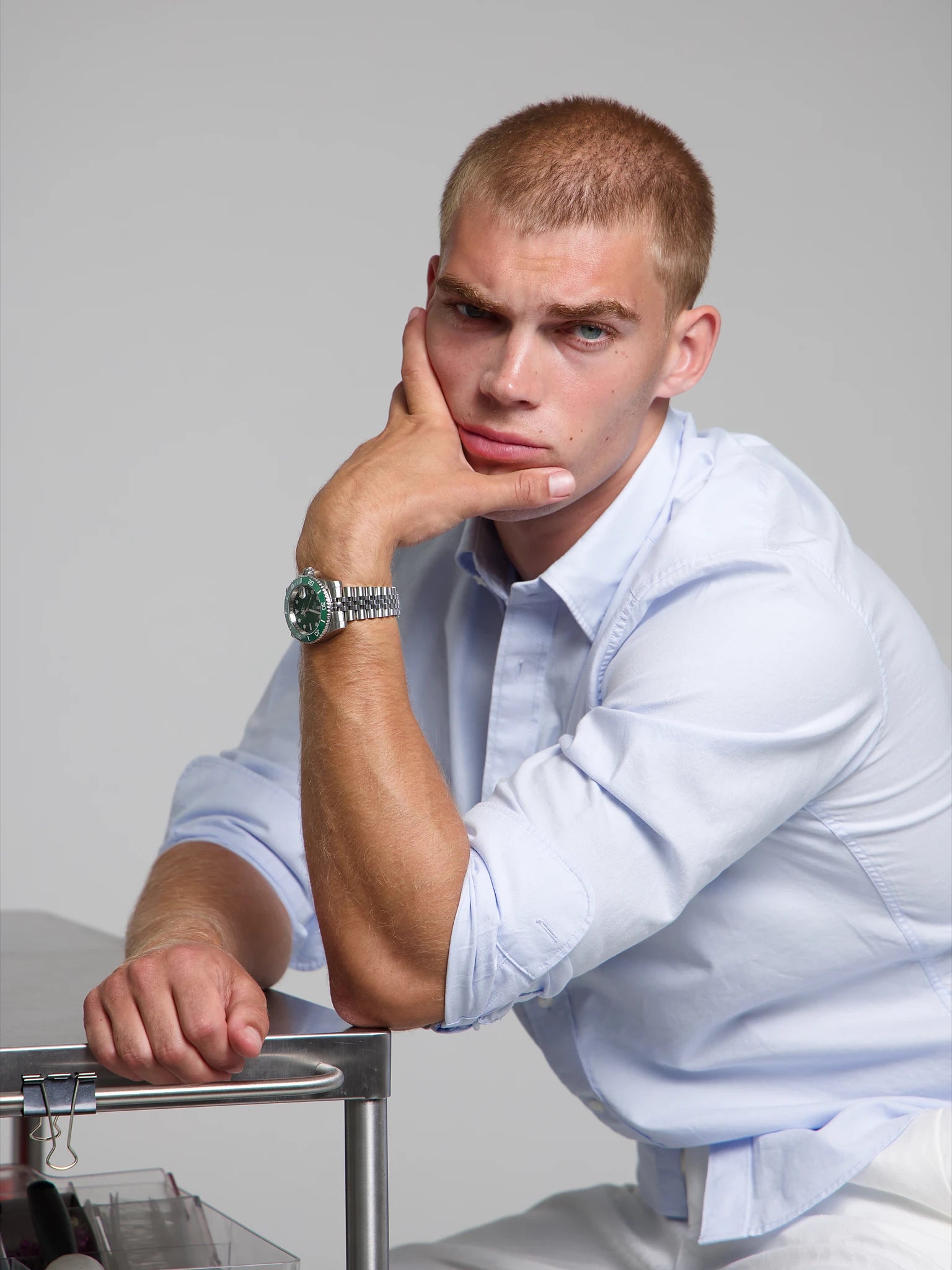 Model wearing a SOREN oceanic all green watch on a jubilee bracelet, seated