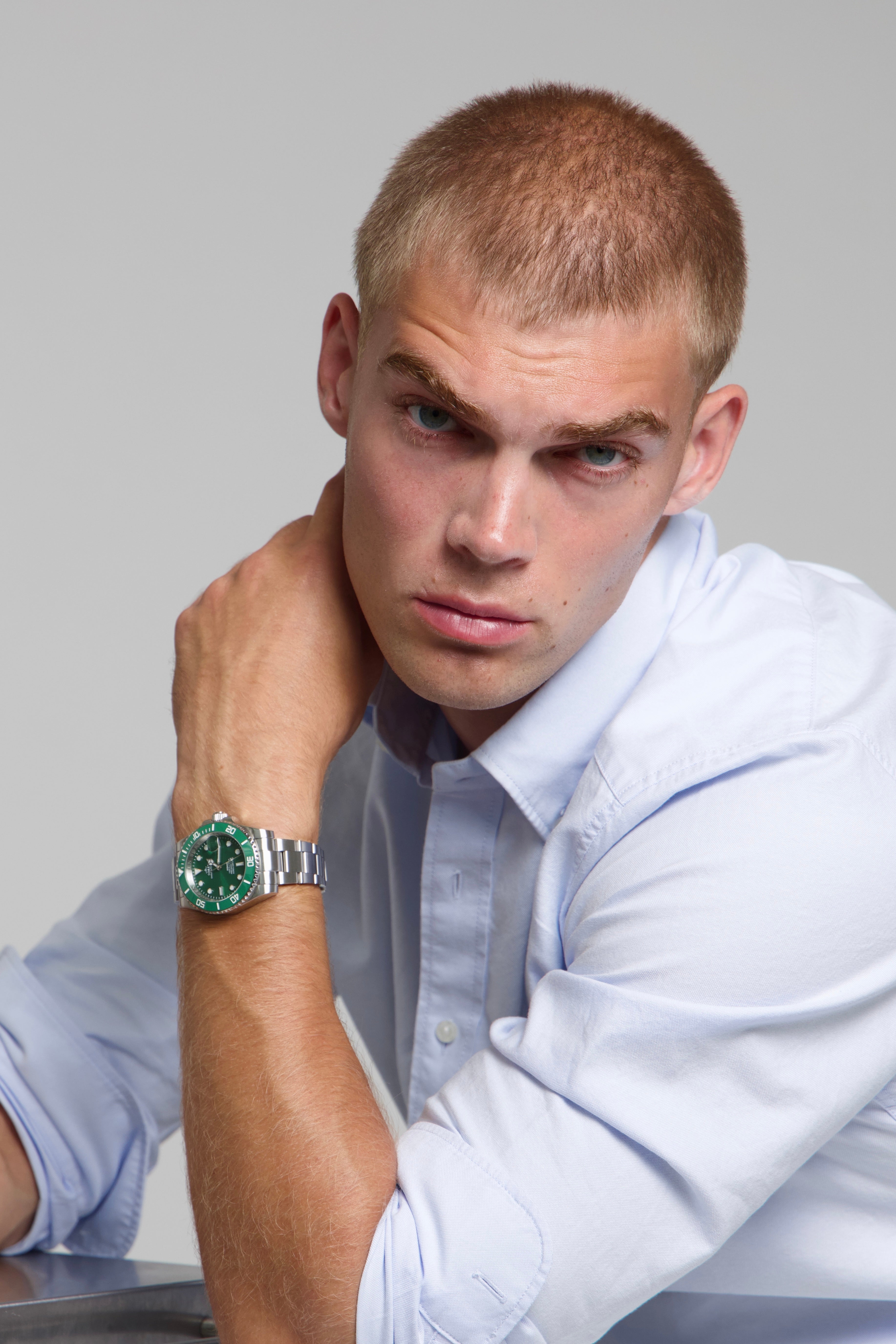 Man wearing a SOREN oceanic all green watch on a oyster bracelet, seated with his arm on his leg