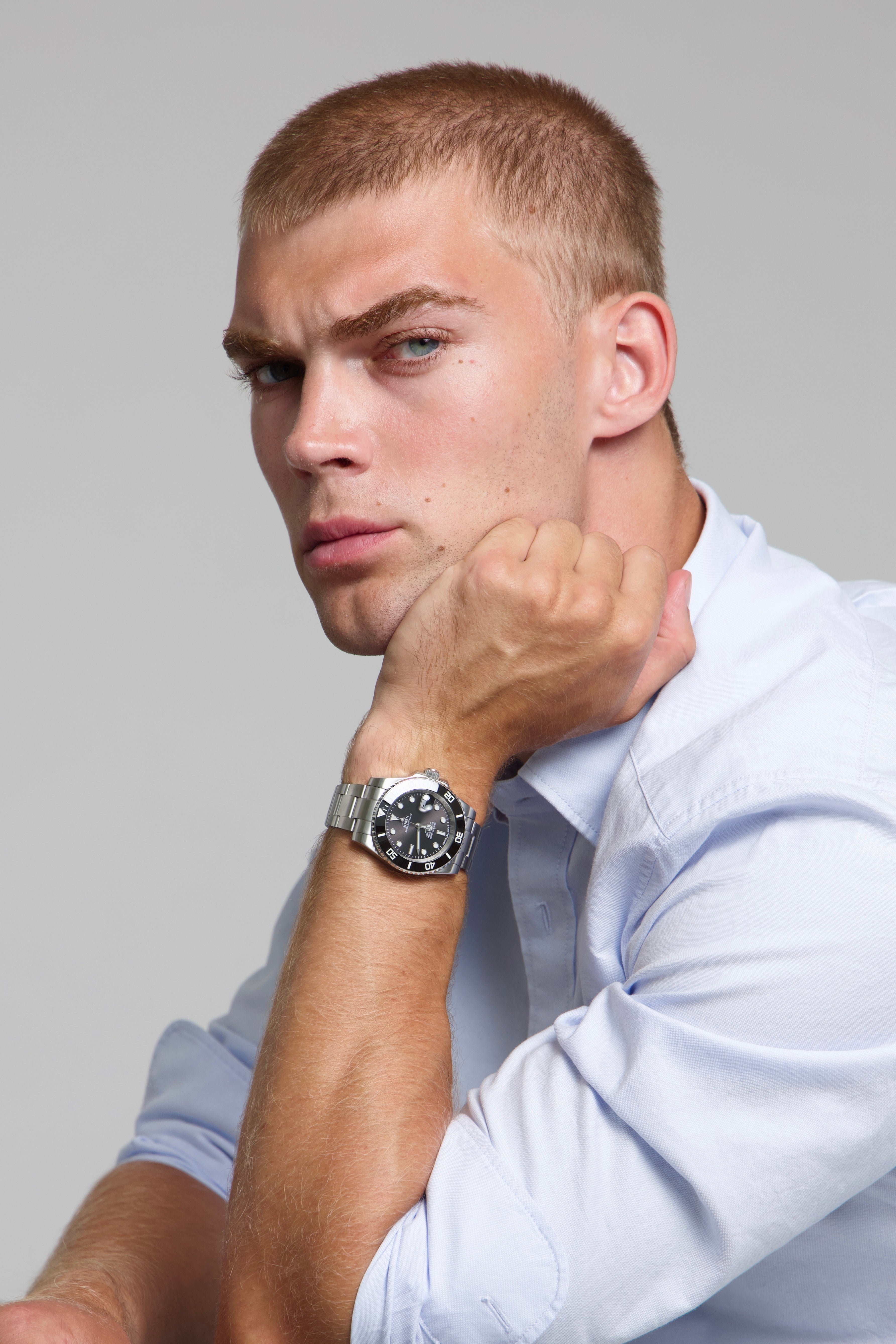 Model wearing a SOREN oceanic black watch on a oyster bracelet, seated