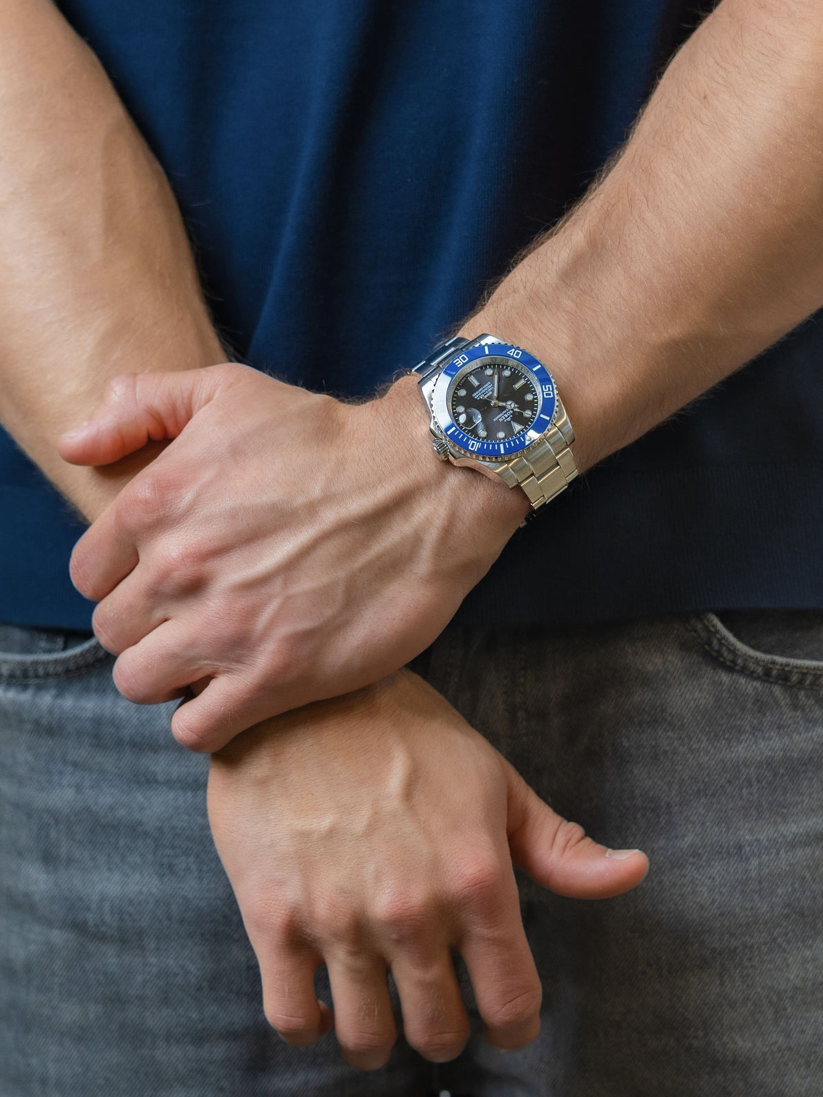 SOREN Oceanic Swiss automatic dive watch with a blue bezel on a 3-link steel bracelet, shown with hands clasped together