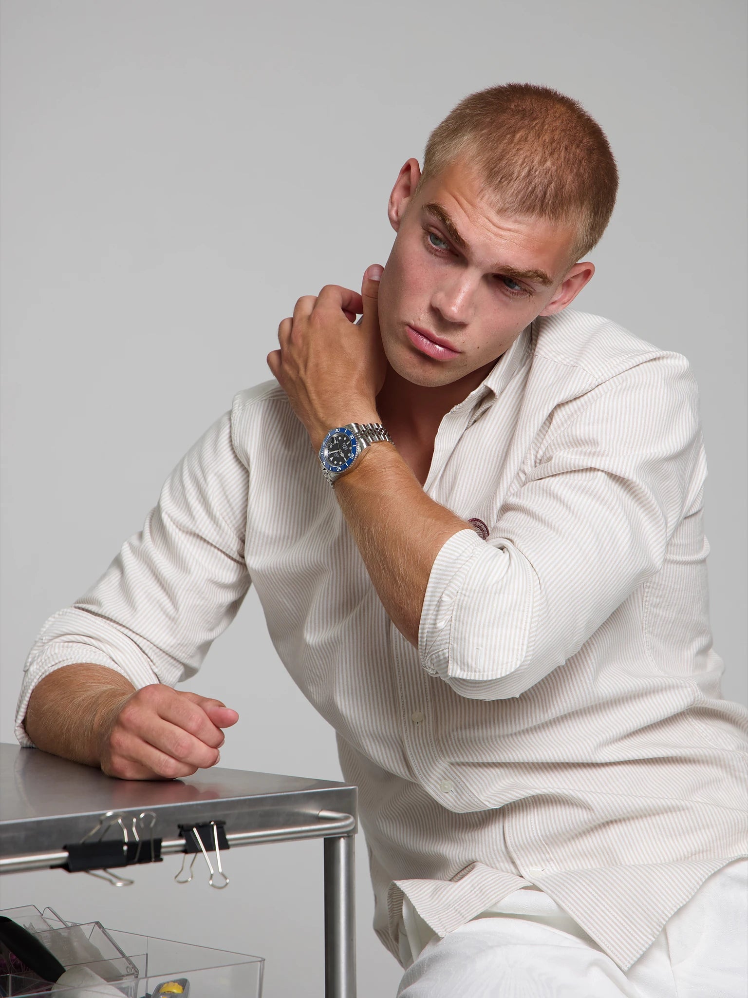 Model wearing a SOREN oceanic blue watch on a jubilee bracelet, seated