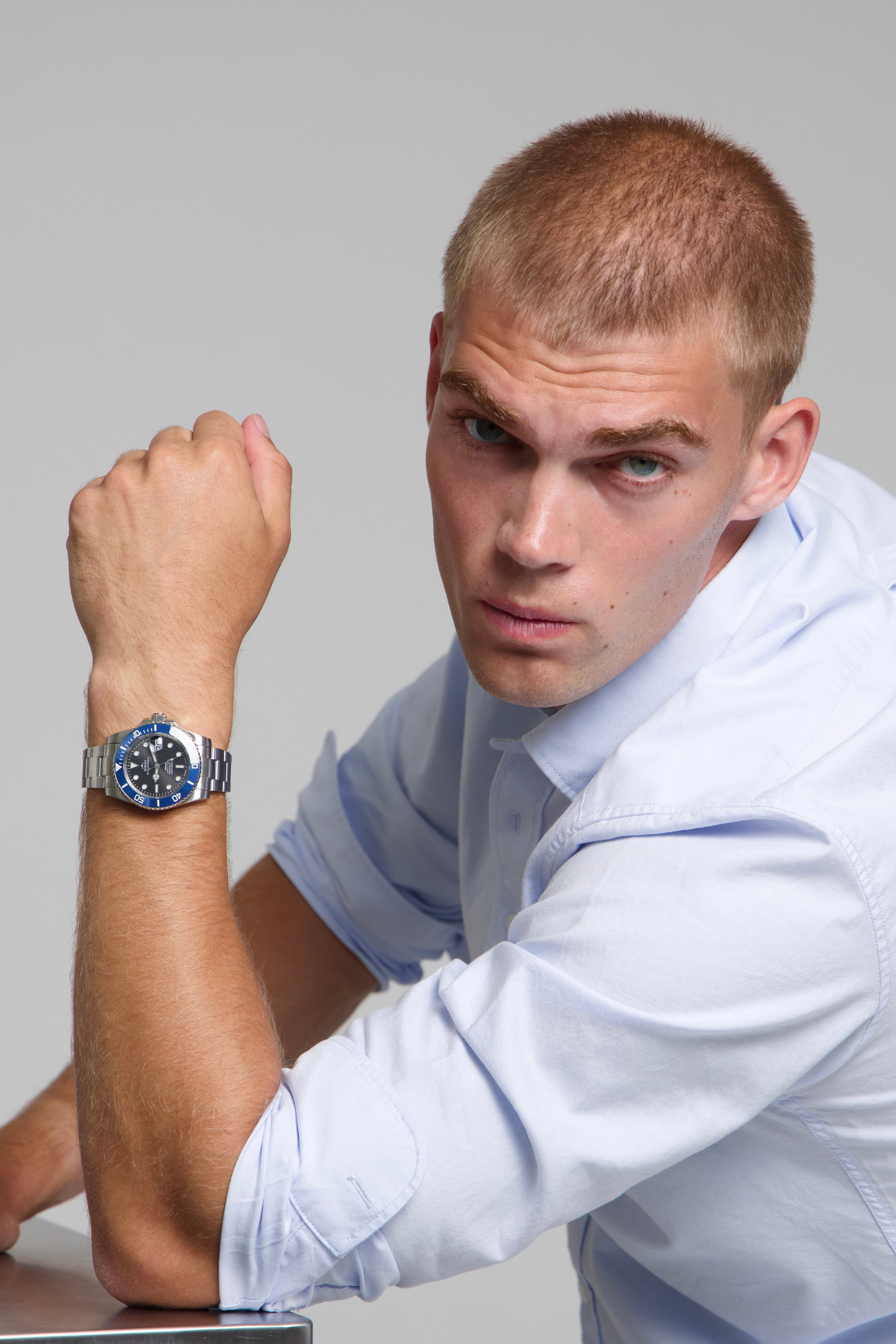 Model wearing a SOREN oceanic blue watch on a oyster bracelet, seated