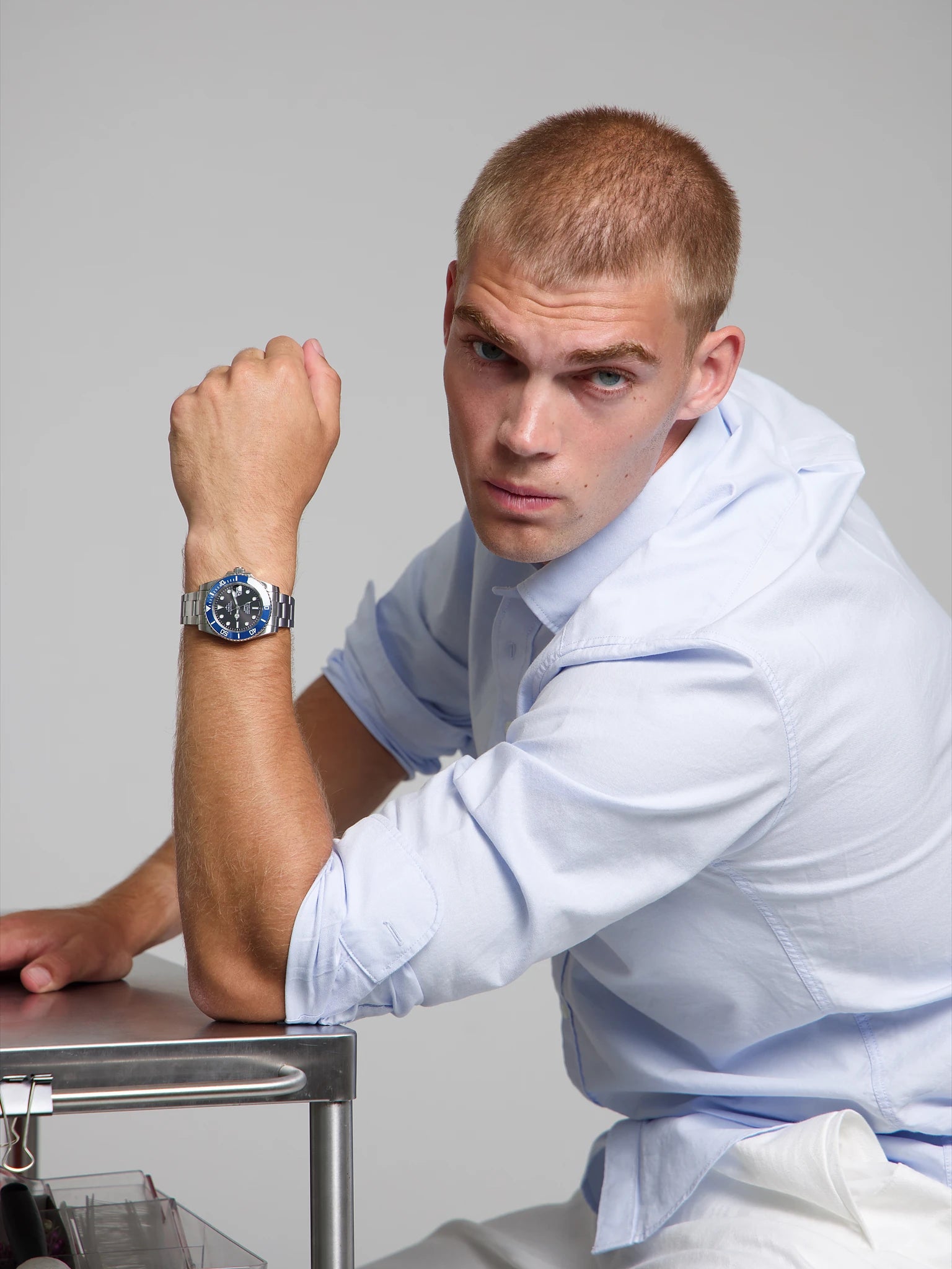 Model wearing a SOREN oceanic blue watch on a oyster bracelet, seated