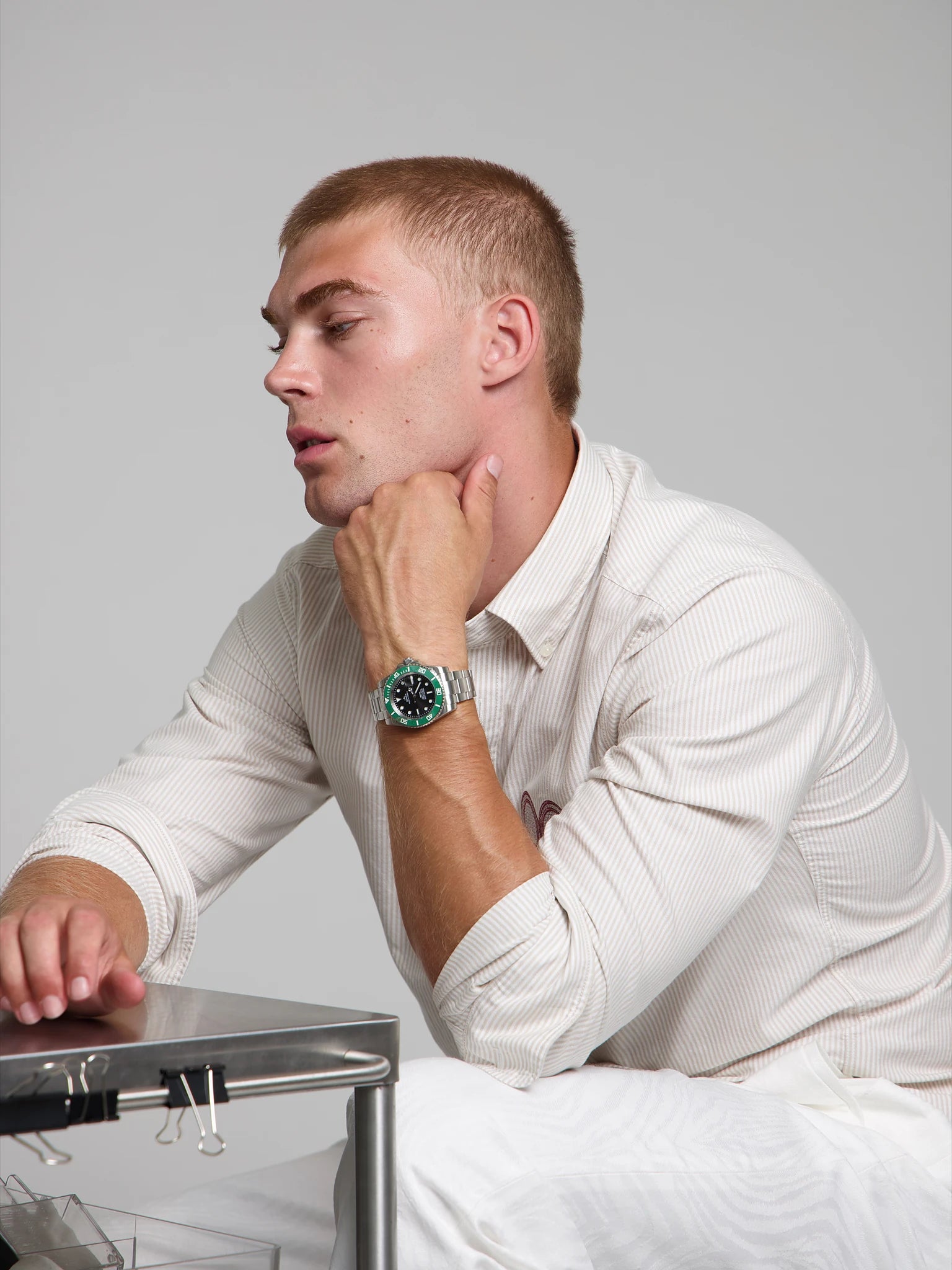 Model wearing a SOREN oceanic green watch on a oyster bracelet, seated