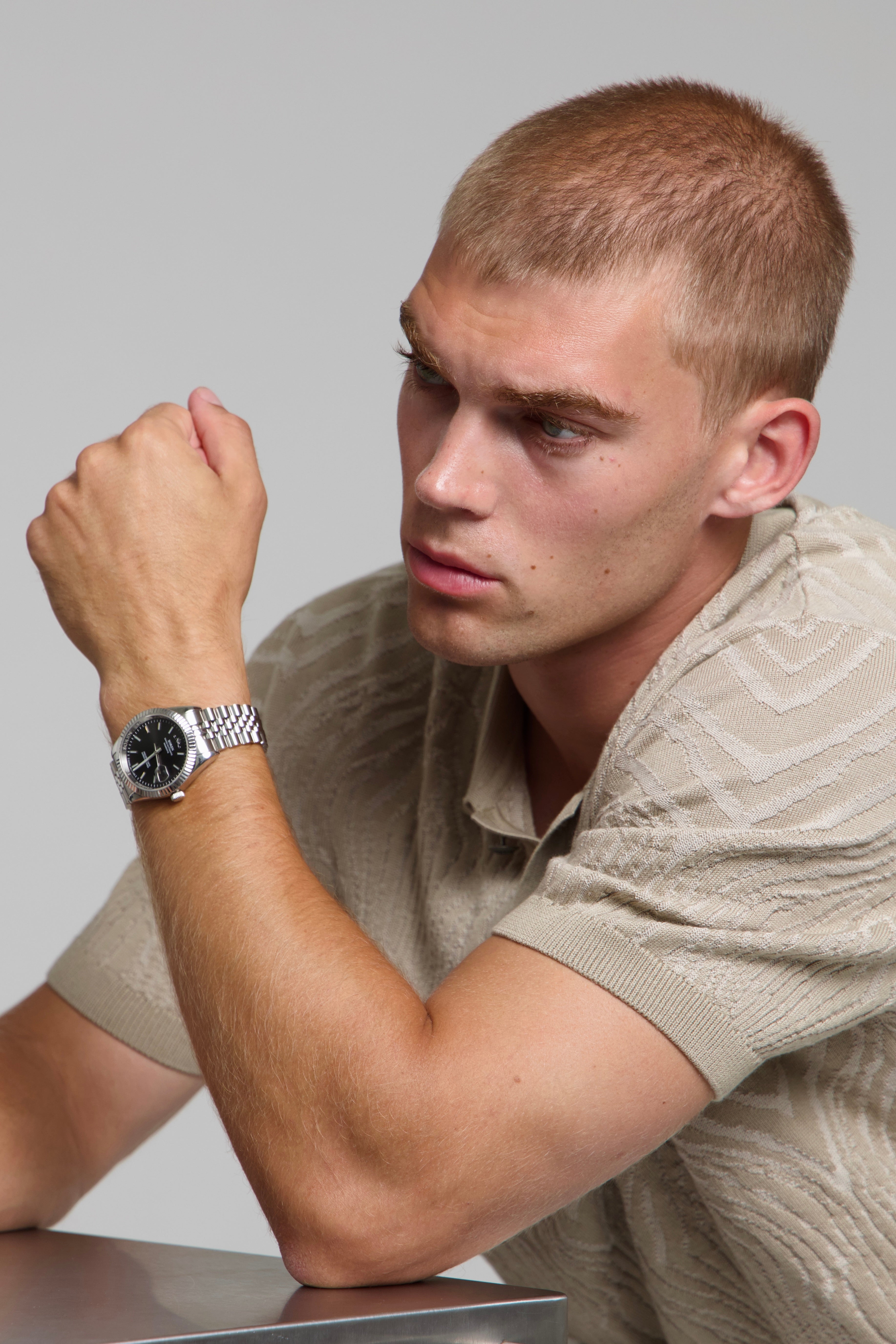 Model wearing a SOREN Momentis black watch on a jubilee bracelet, seated
