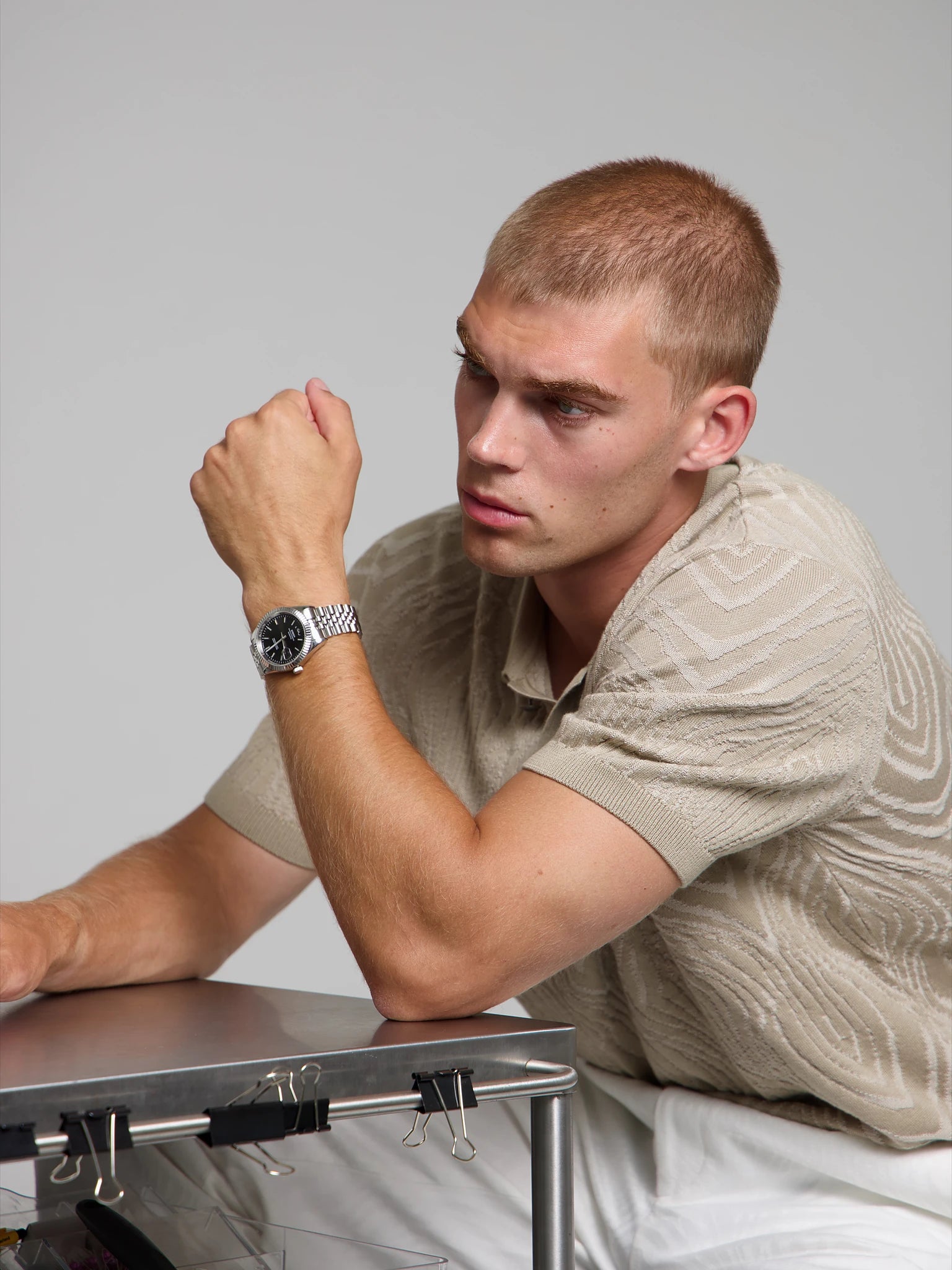 Model wearing a SOREN Momentis black watch on a jubilee bracelet, seated
