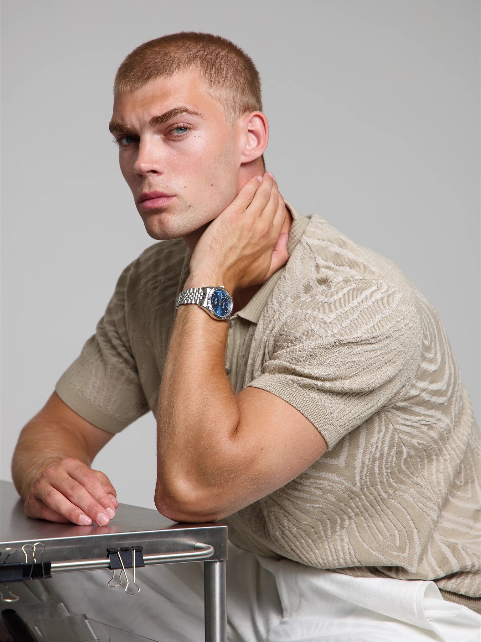 Model wearing a SOREN Momentis blue watch on a jubilee bracelet, seated
