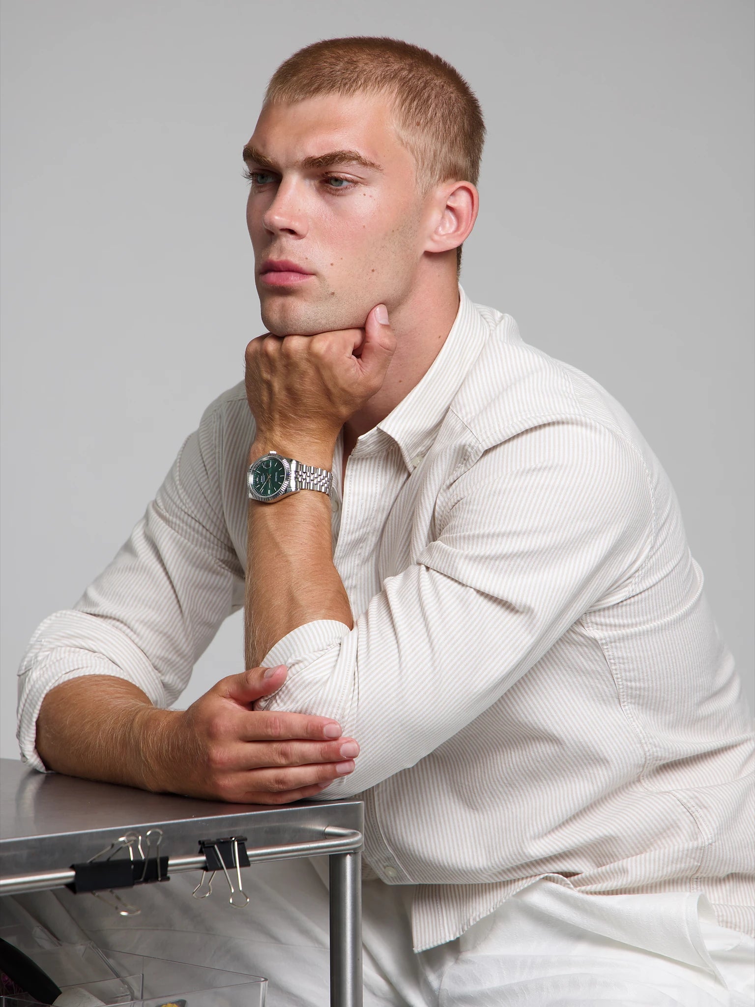 Model wearing a SOREN Momentis green watch on a jubilee bracelet, seated
