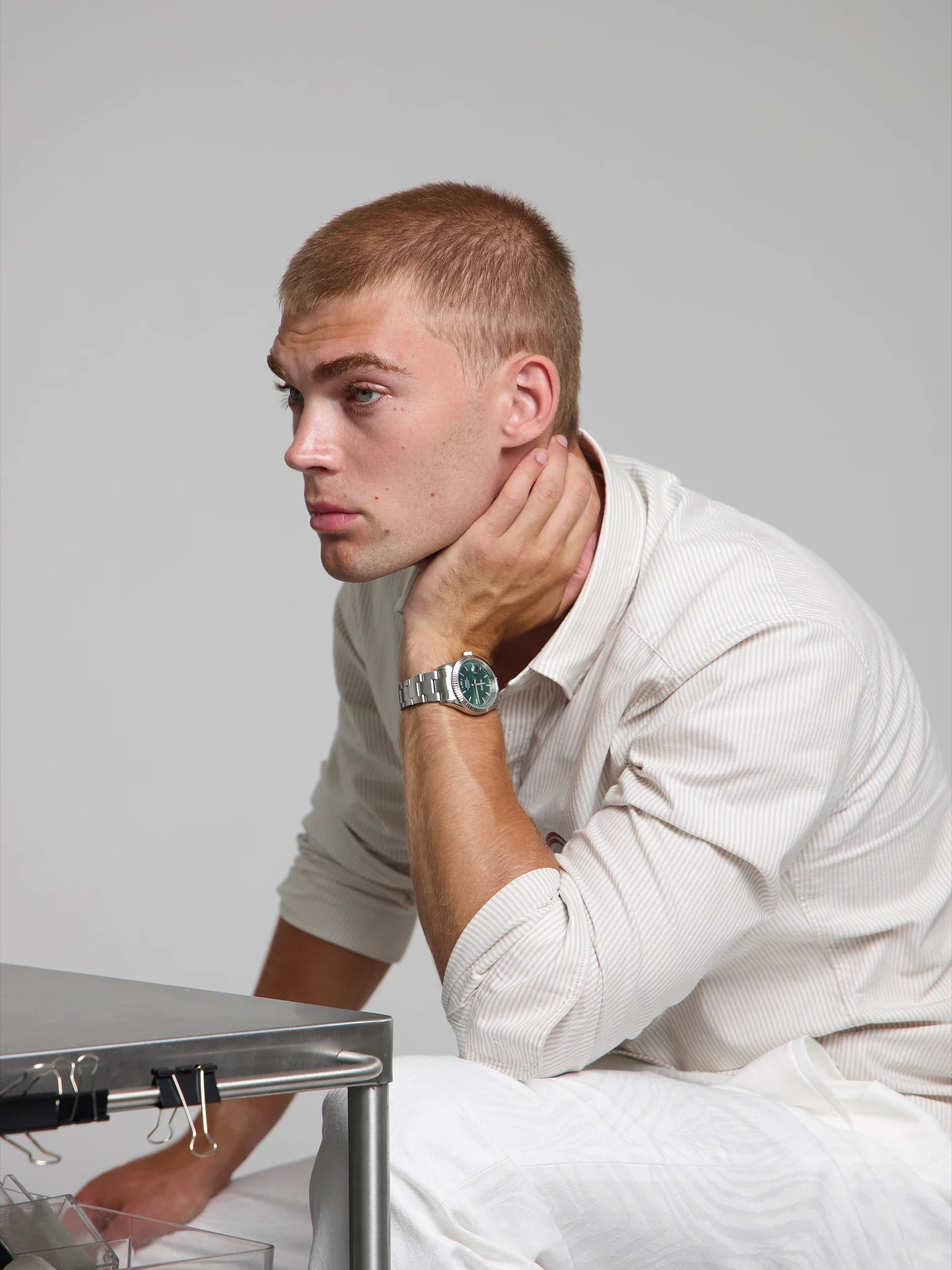Model wearing a SOREN Momentis green watch on a oyster bracelet, seated

