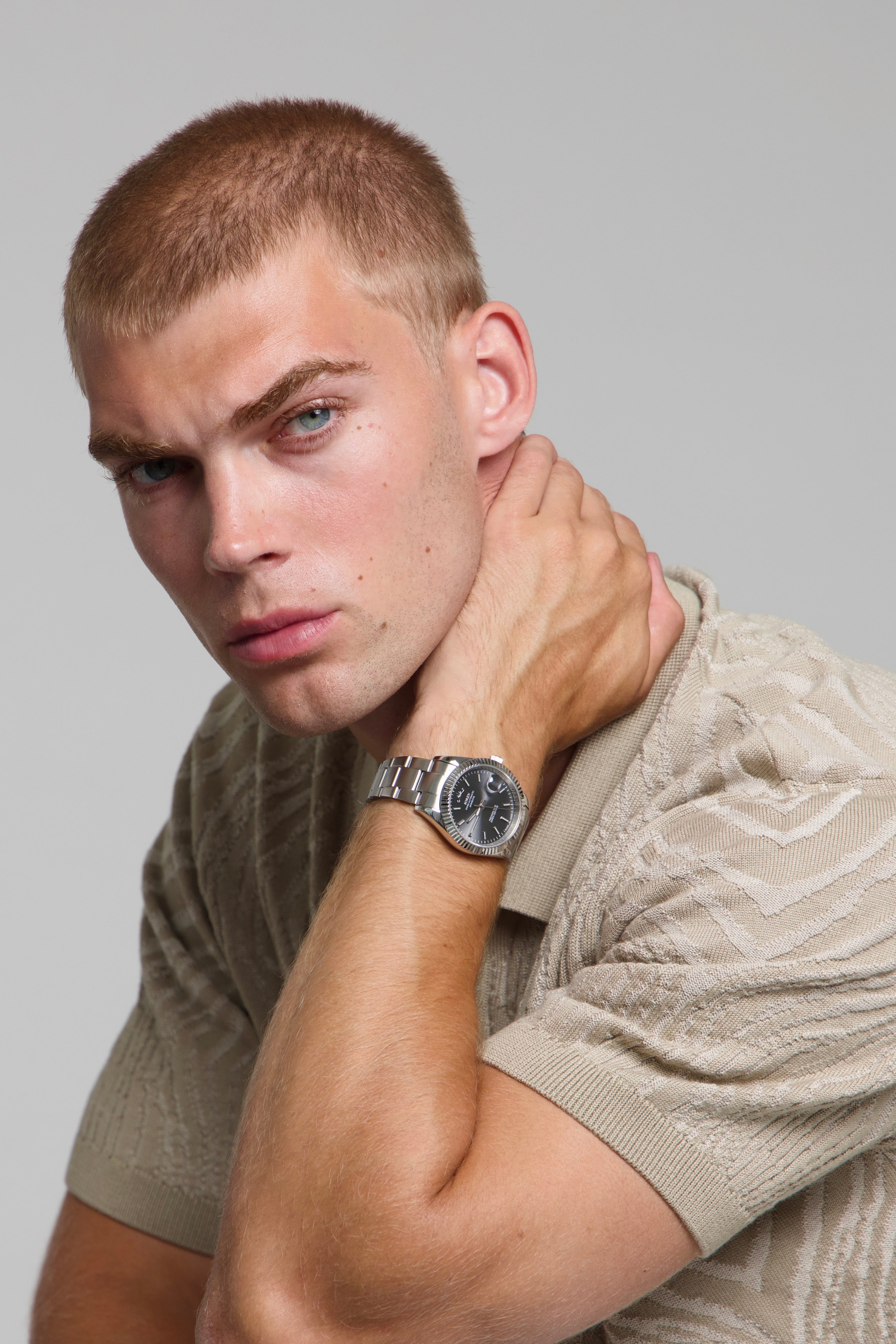 Model wearing a SOREN Momentis grey watch on a oyster bracelet, seated
