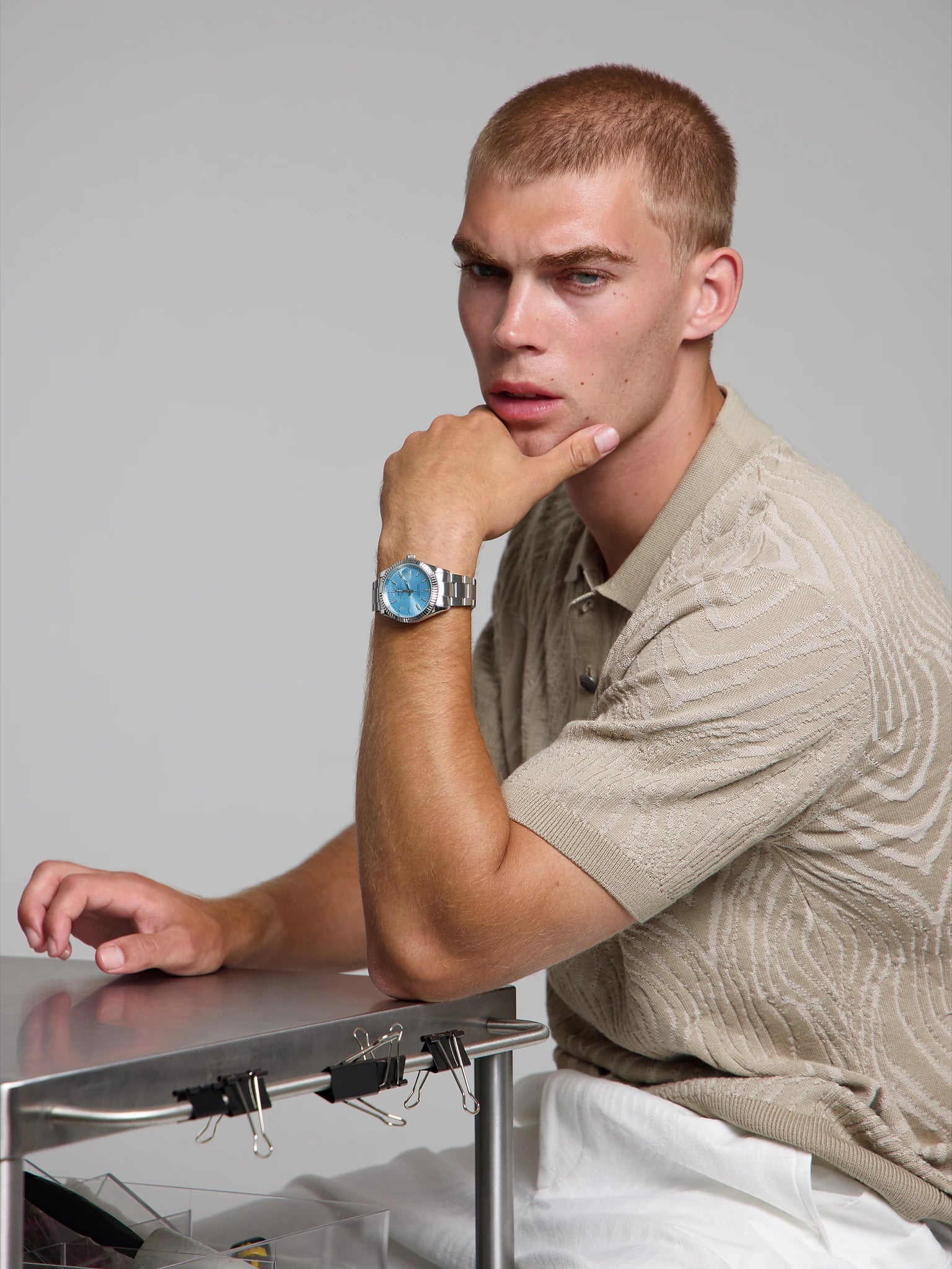 Man wearing a SOREN Momentis ice blue watch on a oyster bracelet, seated with his arm on a table
