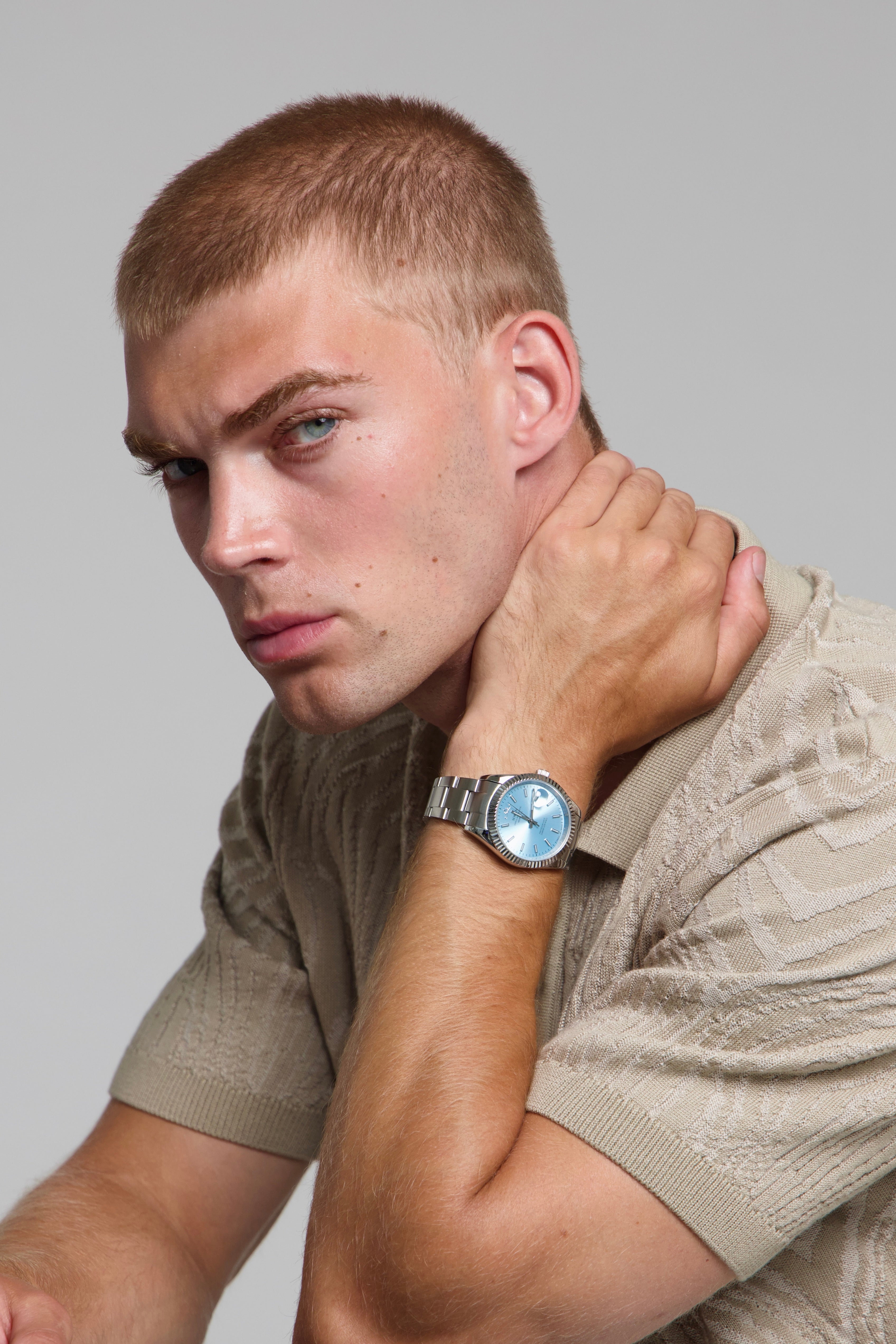 Model wearing a SOREN Momentis ice blue watch on a oyster bracelet, seated
