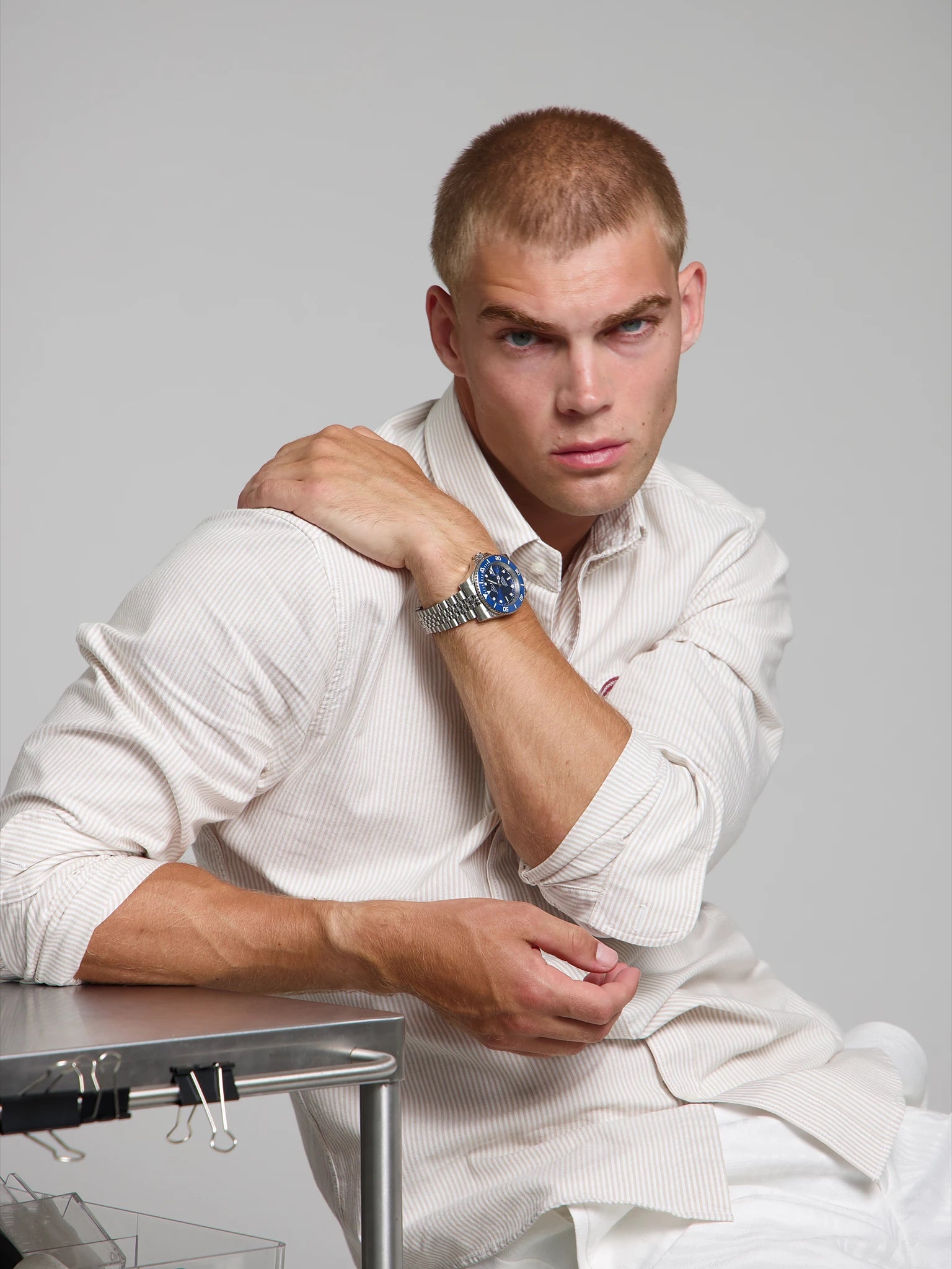 Model wearing a SOREN oceanic all blue watch on a jubilee bracelet, seated
