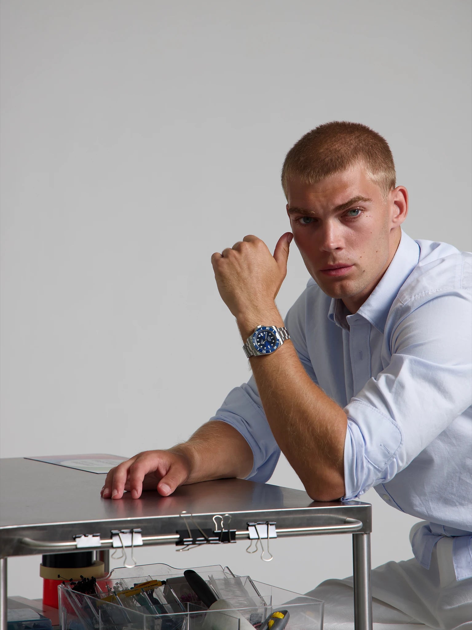 Model wearing a SOREN oceanic all blue watch on a oyster bracelet, seated
