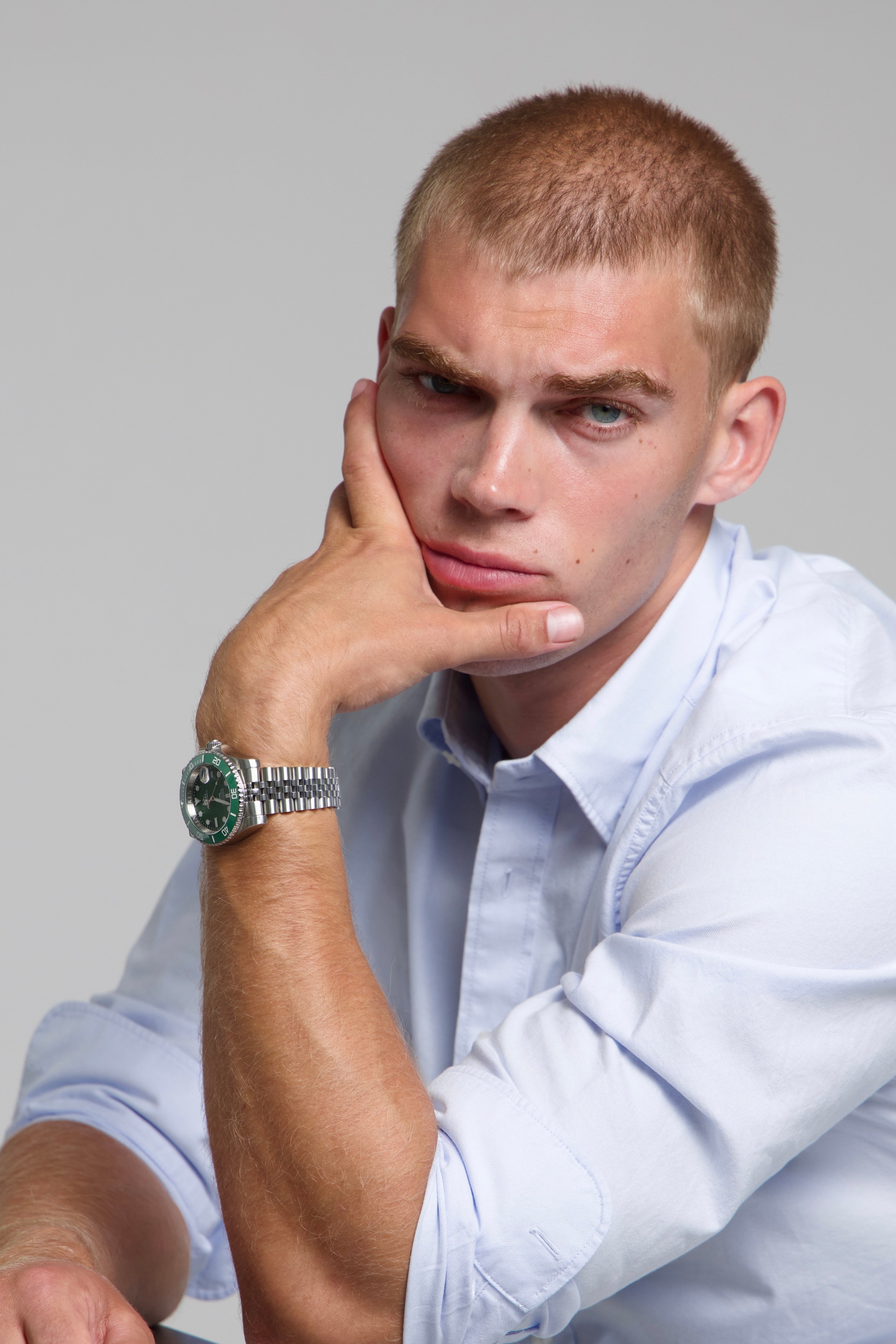 Model wearing a SOREN oceanic all green watch on a jubilee bracelet, seated
