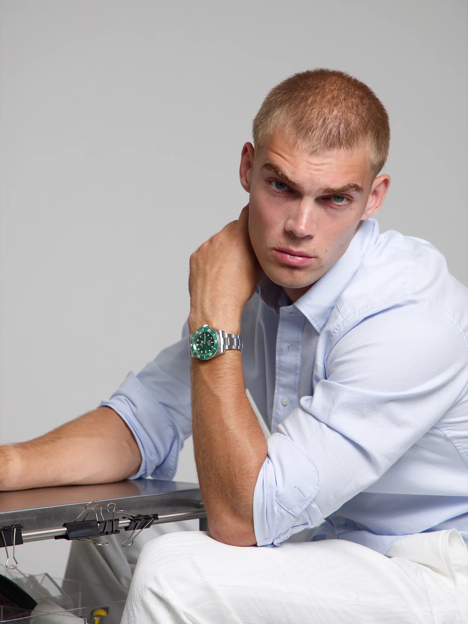 Man wearing a SOREN oceanic all green watch on a oyster bracelet, seated with his arm on his leg
