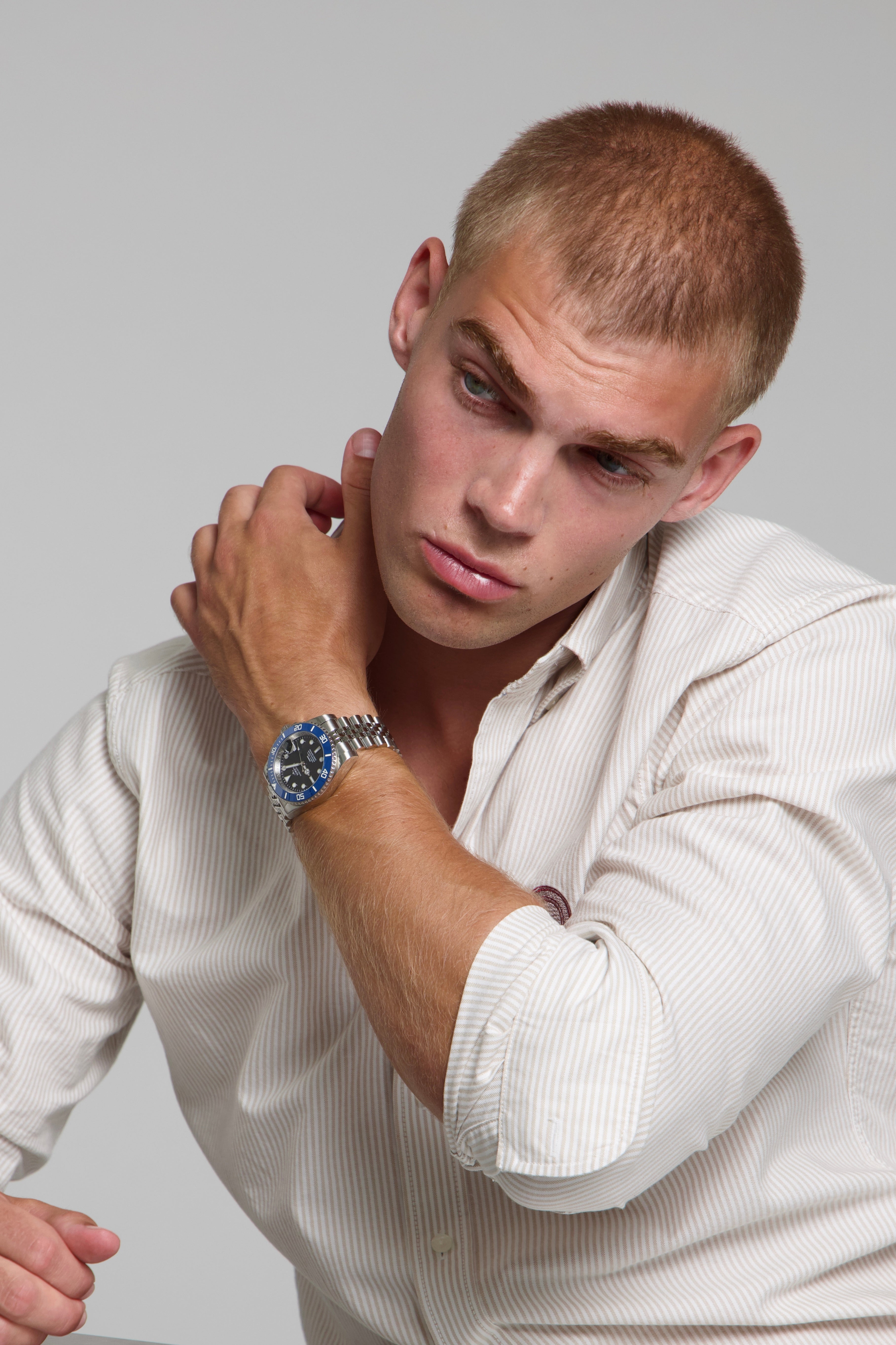 Model wearing a SOREN oceanic blue watch on a jubilee bracelet, seated
