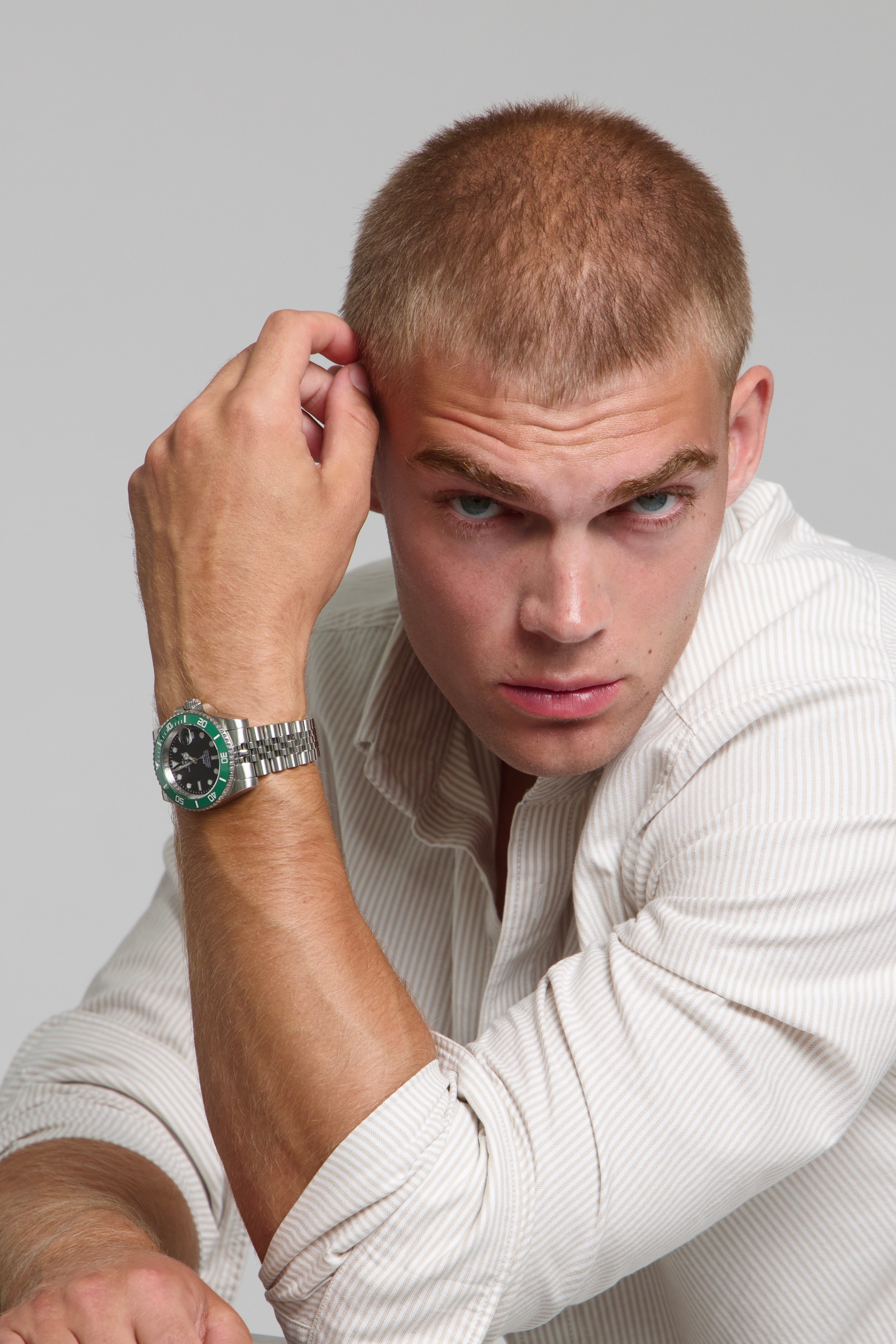 Model wearing a SOREN oceanic green watch on a jubilee bracelet, seated
